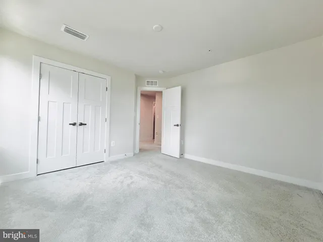 a bedroom with a large bed and flat tv screen on a dresser