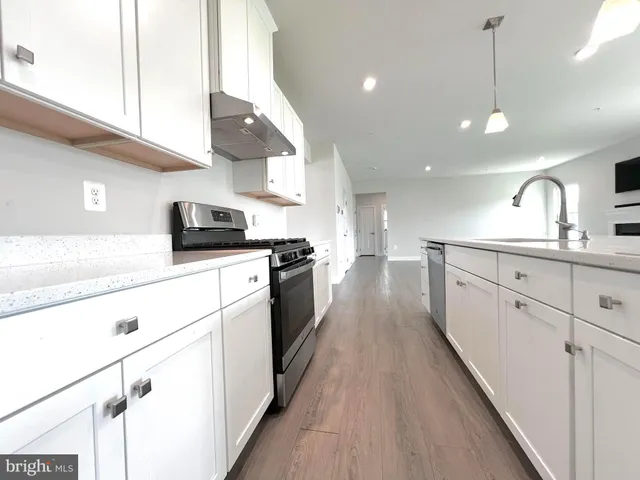 a kitchen with counter top space a sink stainless steel appliances and cabinets