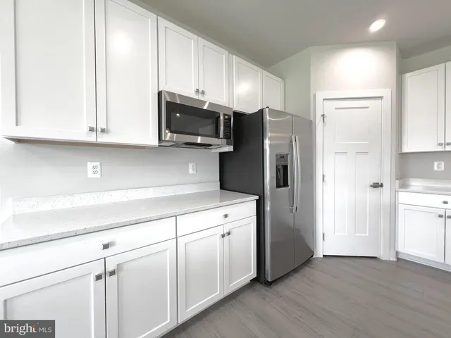 a kitchen with cabinets stainless steel appliances a sink and a window