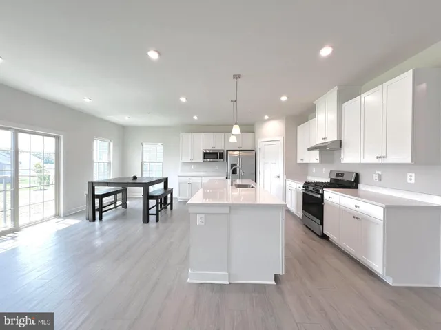 a kitchen with a table chairs refrigerator and window