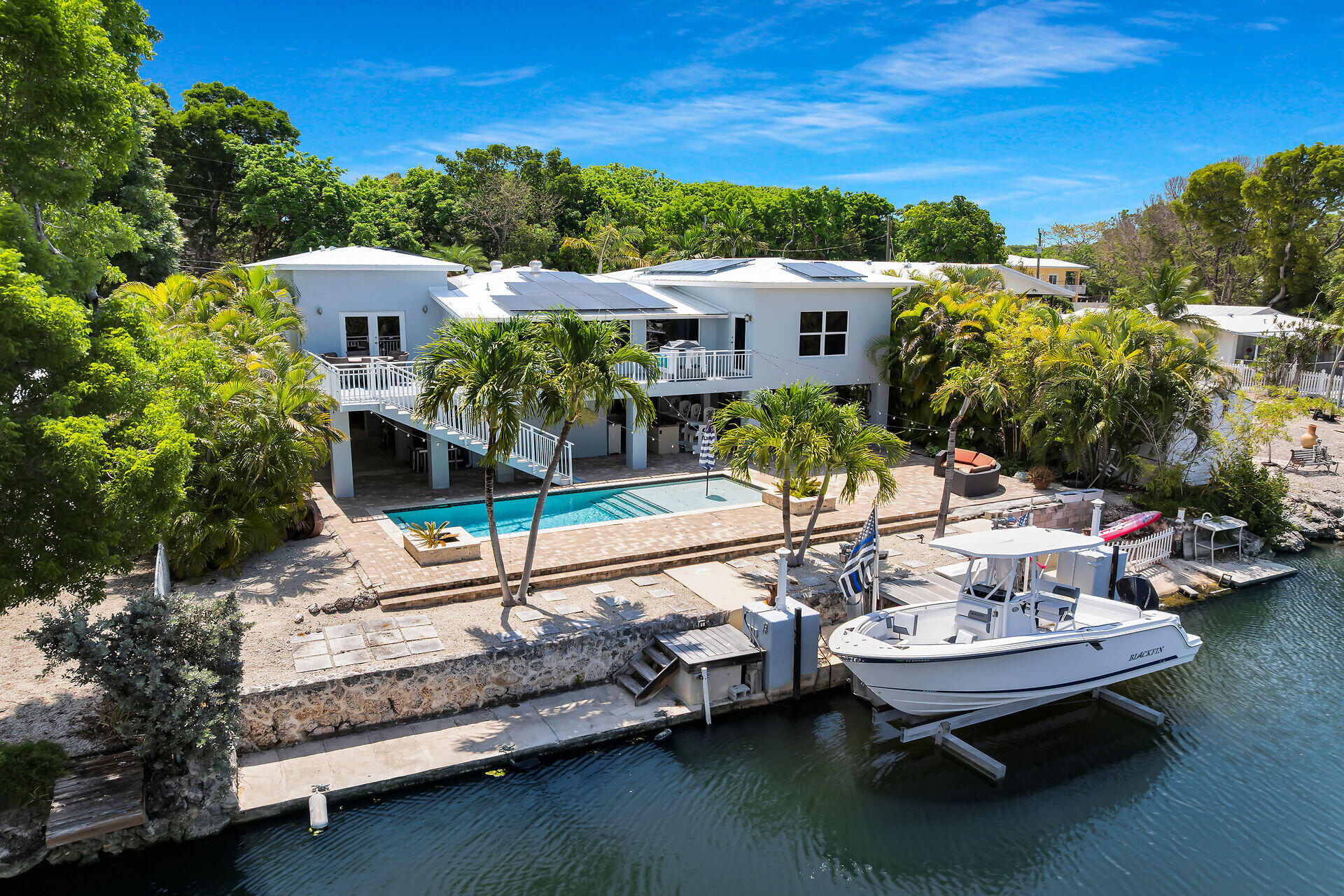 853 Ellen Drive Key Largo, FL 33037 - Photo 1 of 42 a roof deck with table and chairs plants and large trees