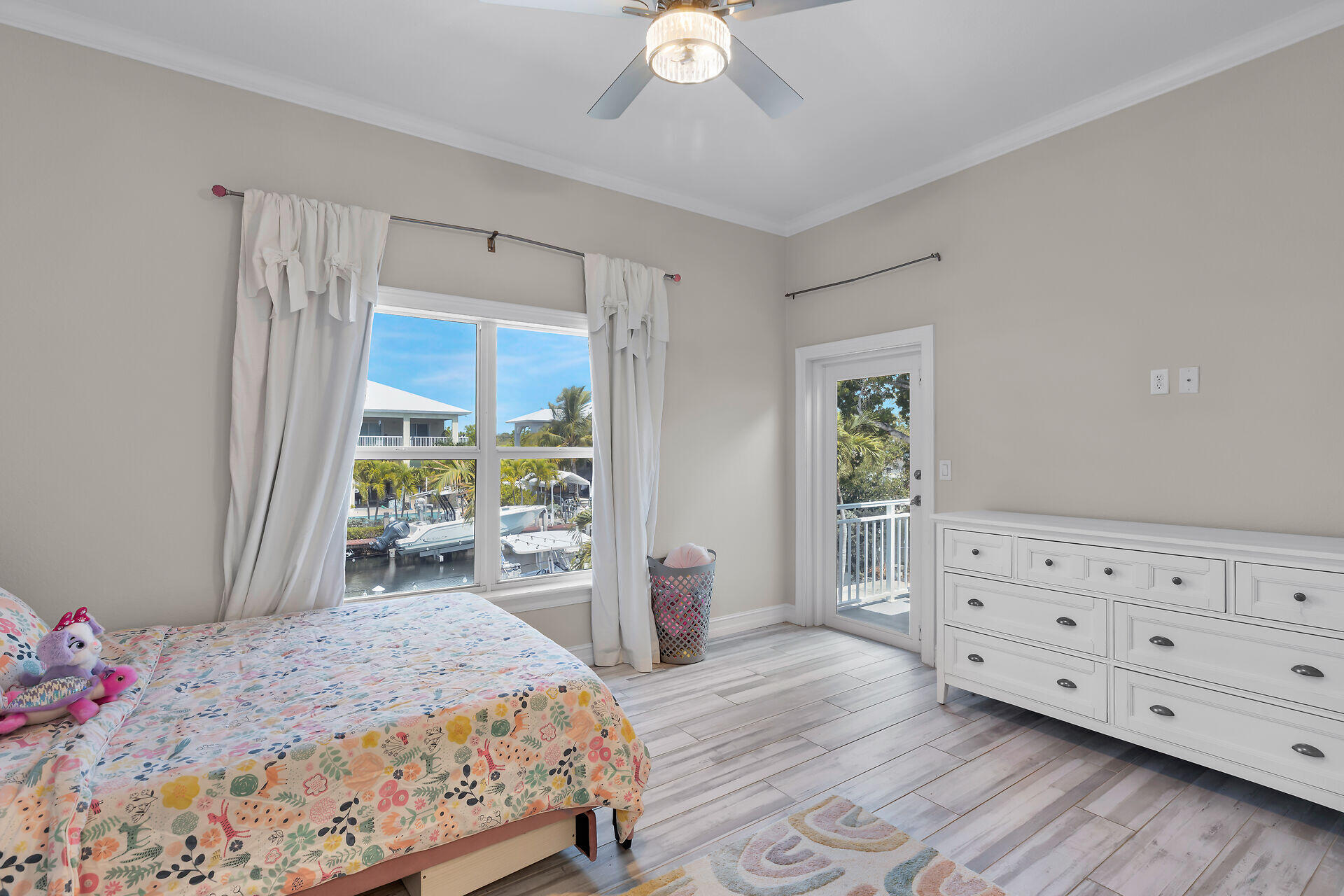 853 Ellen Drive Key Largo, FL 33037 - Photo 23 of 42 a bedroom with a bed a chandelier and a dresser