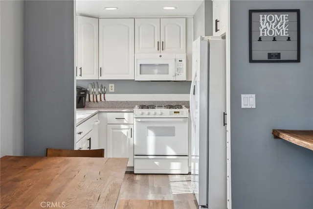 a kitchen with stainless steel appliances a refrigerator and white cabinets
