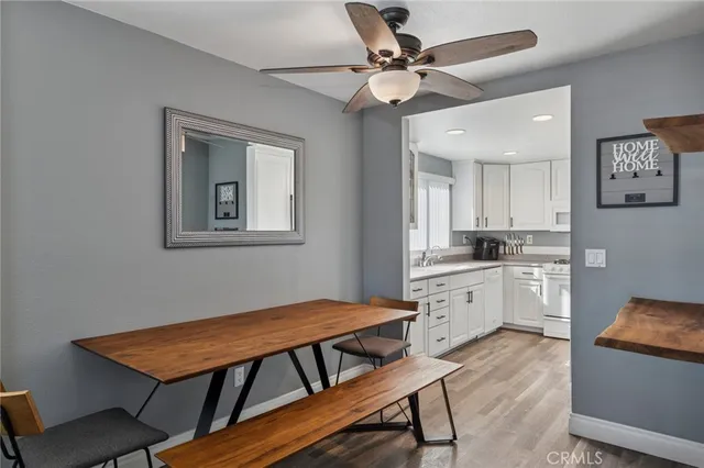 a kitchen with stainless steel appliances granite countertop a stove a sink dishwasher and a refrigerator with wooden floor