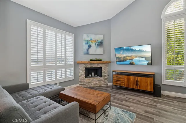 a living room with furniture a flat screen tv and a fireplace