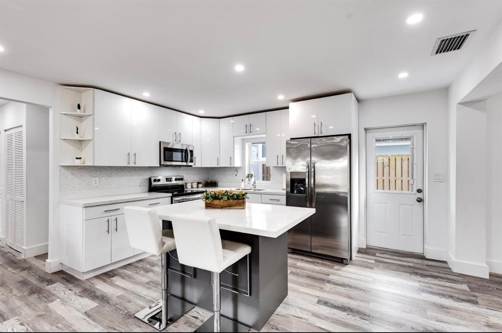 a kitchen with stainless steel appliances refrigerator sink and cabinets