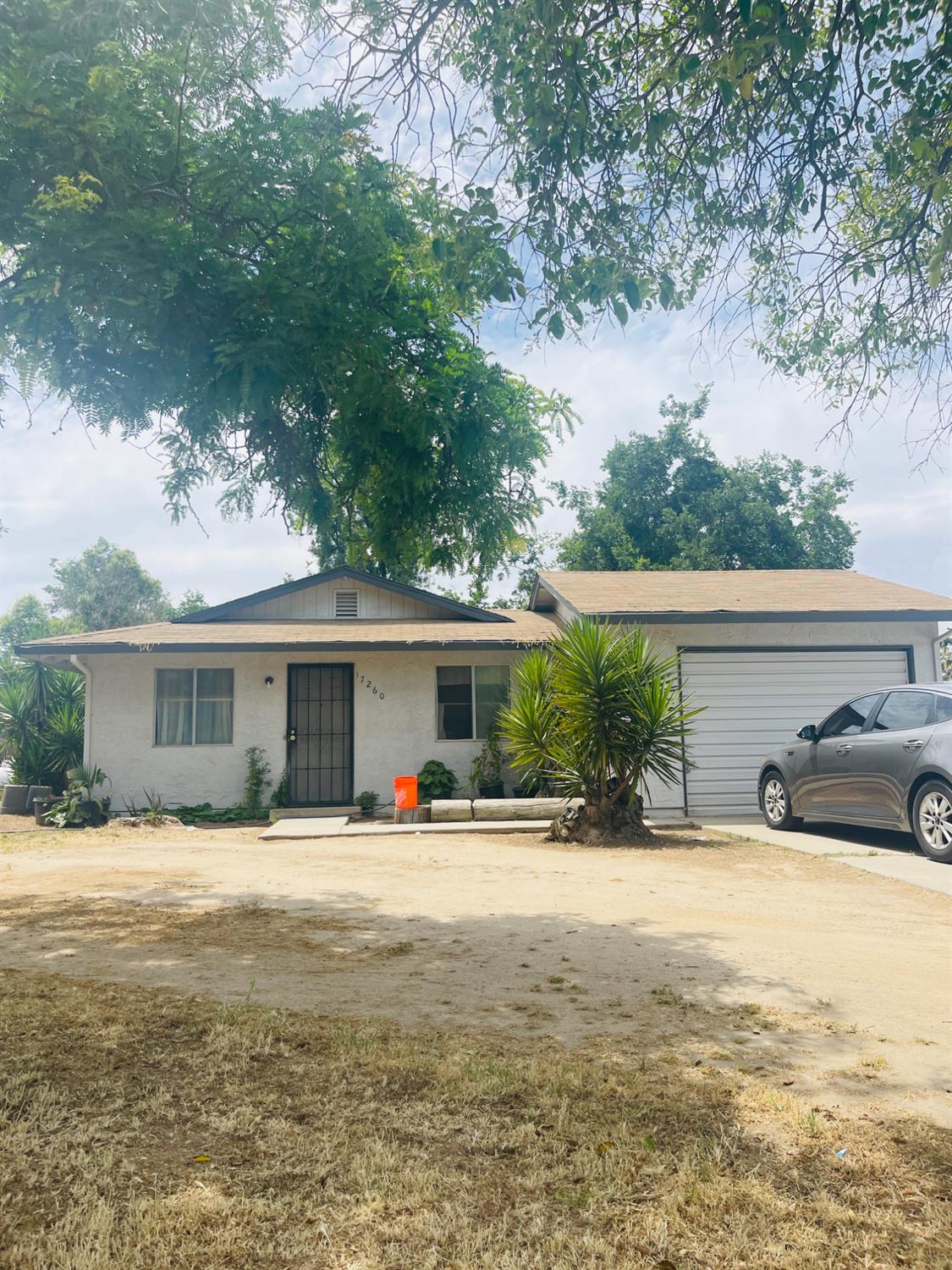 17260 Rodeo Drive Madera, CA 93638 - Photo 3 of 19 a front view of house with yard and trees in the background