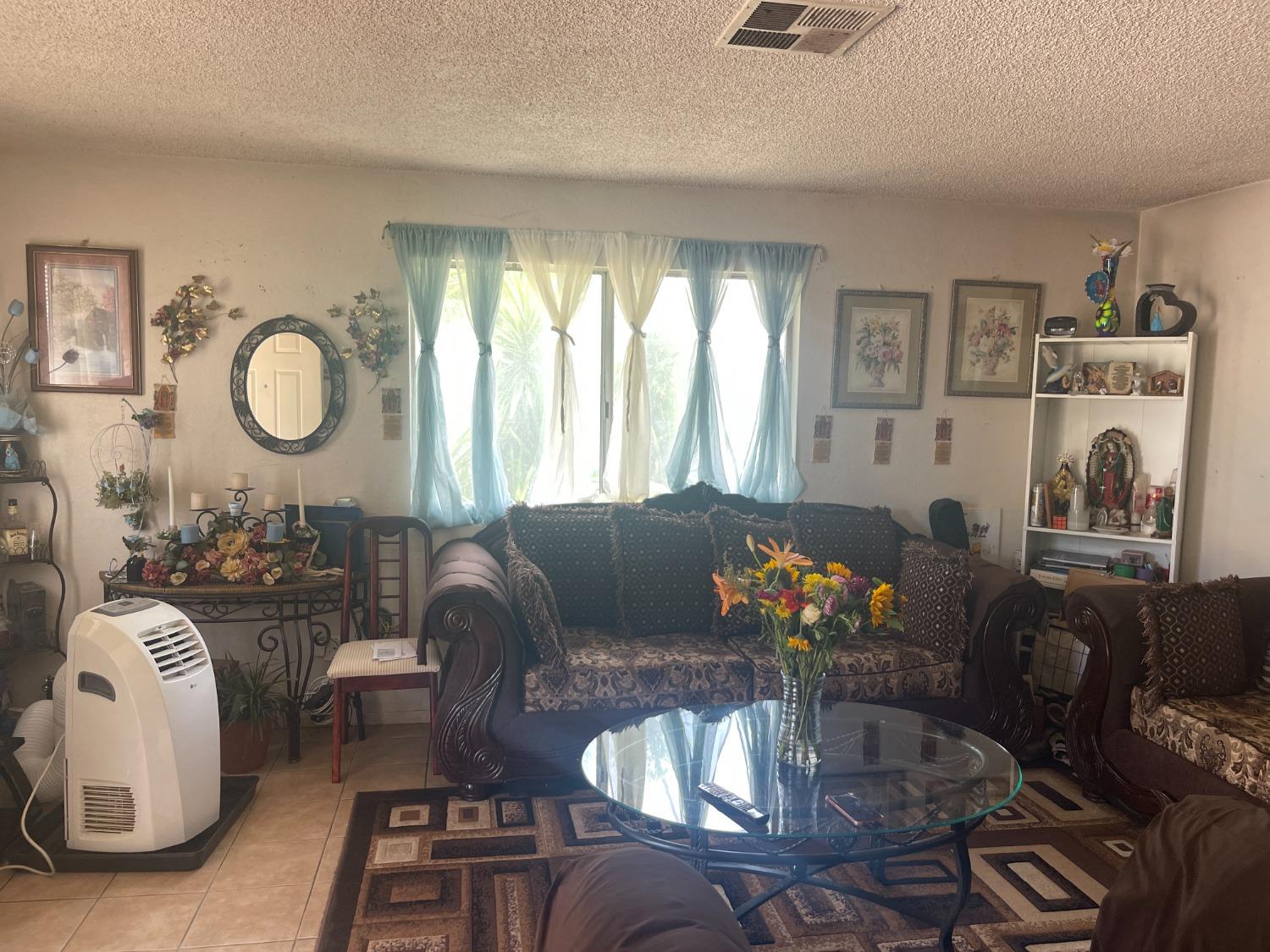 17260 Rodeo Drive Madera, CA 93638 - Photo 4 of 19 a living room with furniture chandelier and a large window
