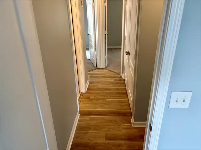 a view of a hallway with wooden floor and staircase