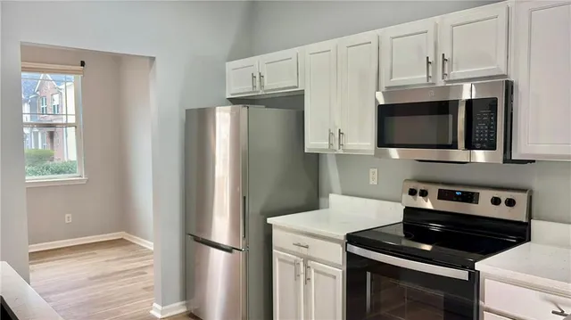 a kitchen with stainless steel appliances a refrigerator stove and microwave