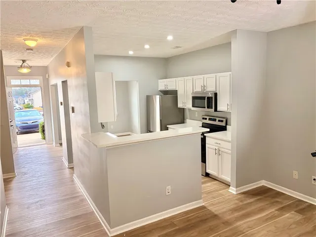 a kitchen with white cabinets and stainless steel appliances