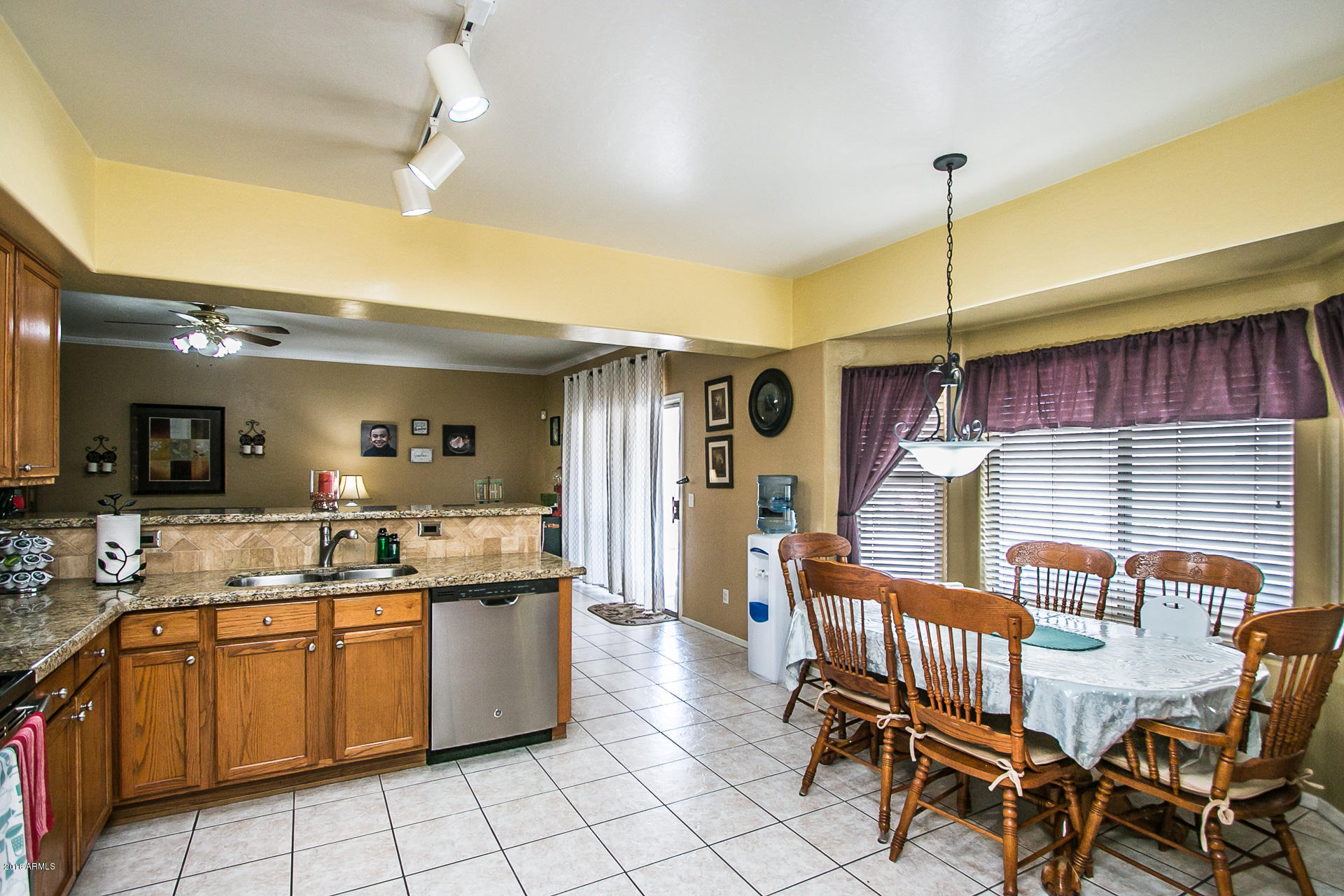 618 East Ranch Road Gilbert, AZ 85296 - Photo 16 of 32 a kitchen with kitchen island a chandelier dining table and chairs