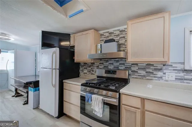 a kitchen with refrigerator a microwave a sink and cabinets