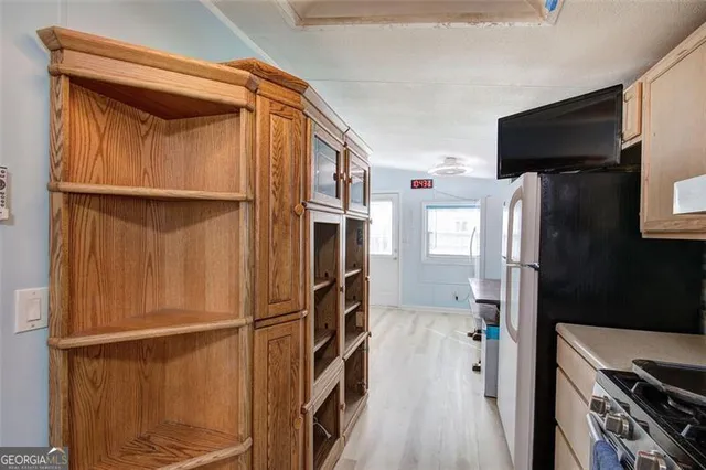 a kitchen with a refrigerator and a stove top oven