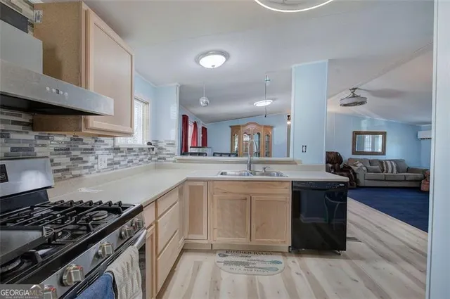 a kitchen with a sink stove and wooden floor