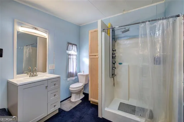 a bathroom with a shower sink mirror and toilet