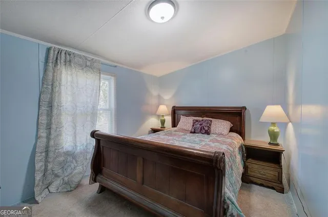 a bedroom with a bed and a lamp on table