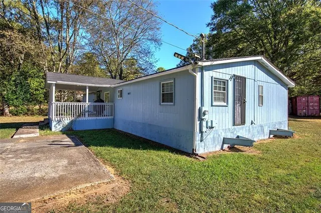 a view of a house with backyard and trees