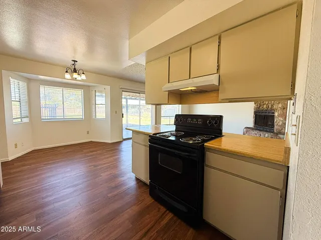 a kitchen with a stove wooden floor and a window
