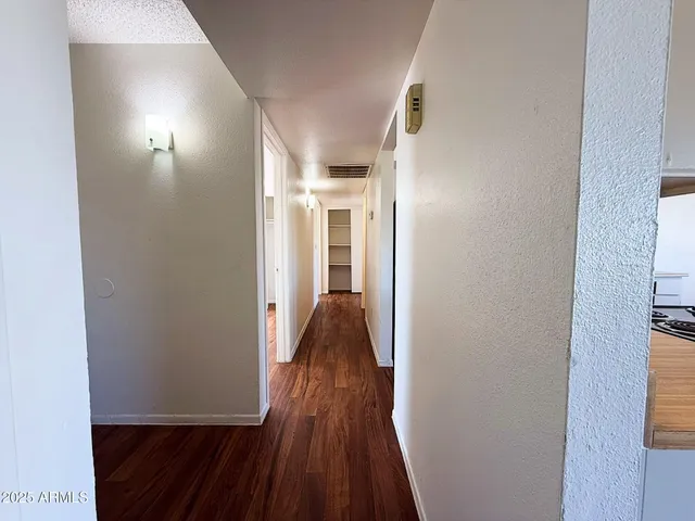 a view of a hallway with wooden floor and closet