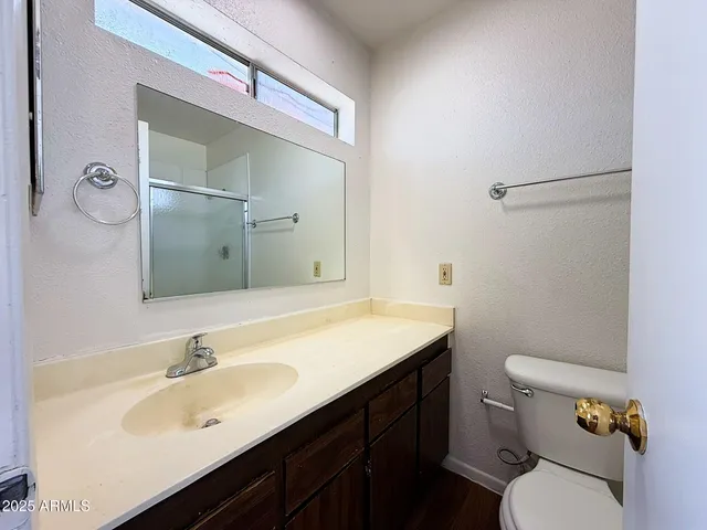 a bathroom with a sink a toilet a mirror and shower