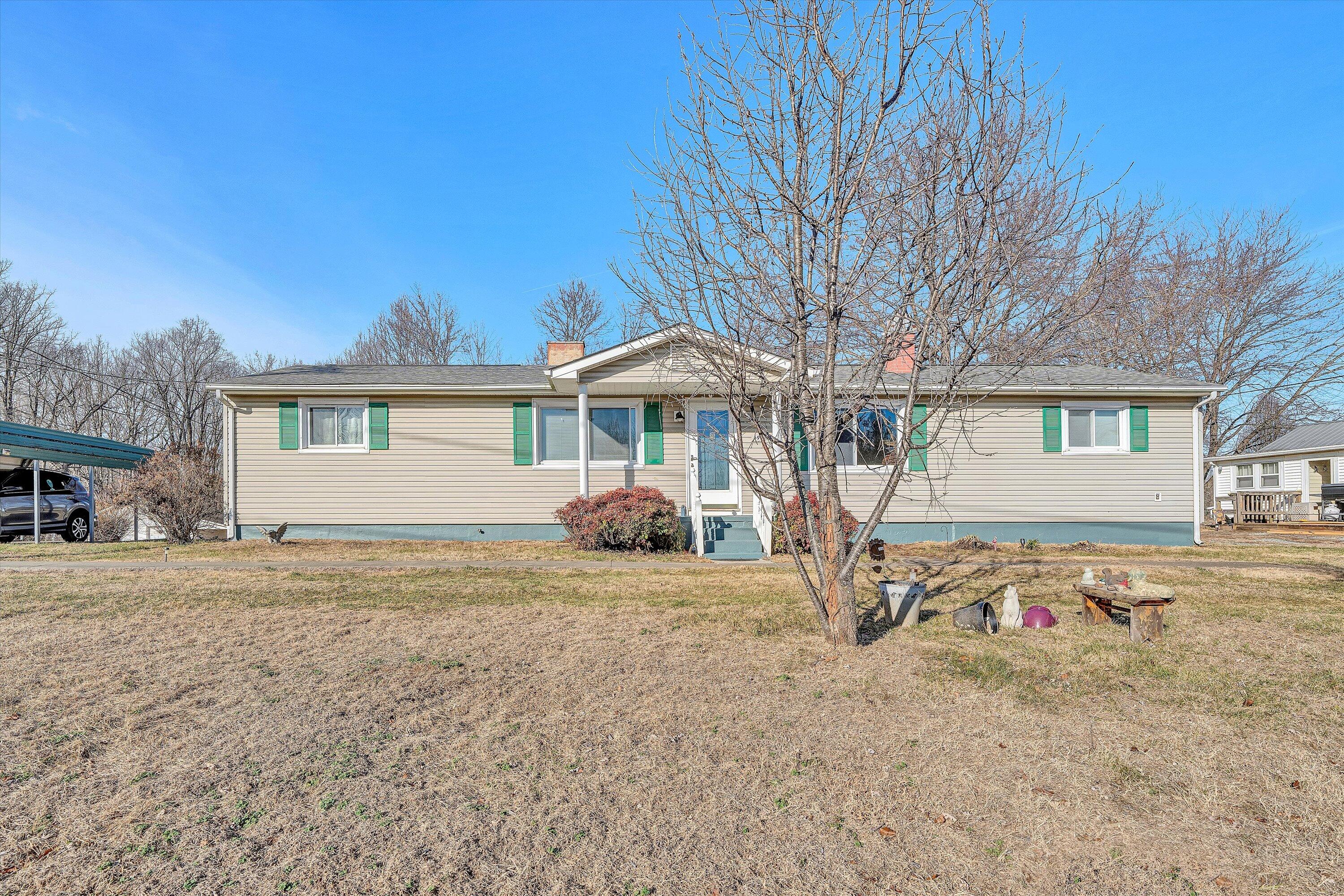 a view of a house with backyard and a tree