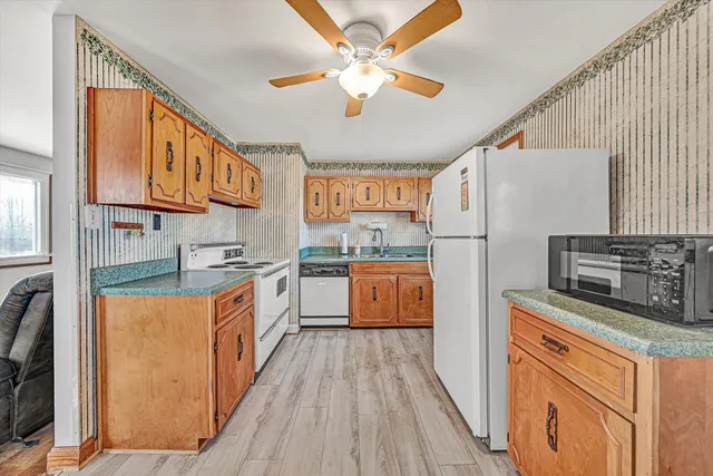 a large kitchen with stainless steel appliances granite countertop a stove a sink dishwasher and a refrigerator
