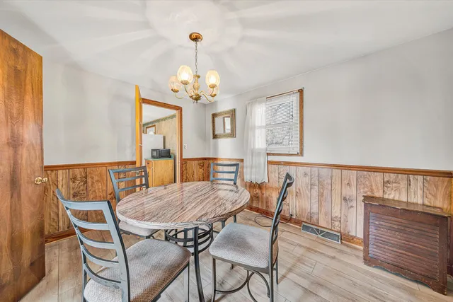 a view of a dining room with furniture wooden floor and chandelier