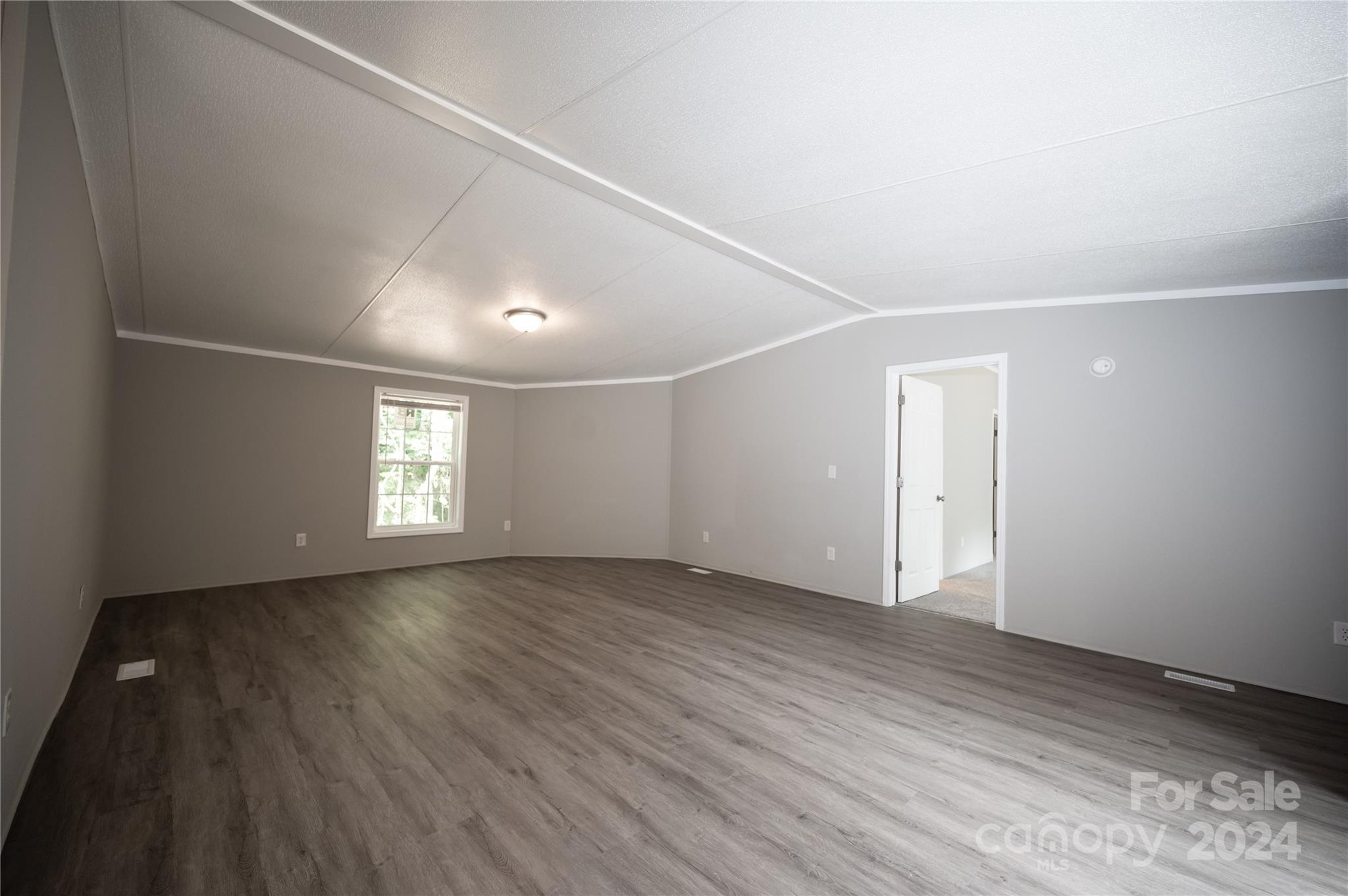 2574 Orchard Road Smyrna, SC 29743 - Photo 6 of 17 a view of an empty room with a window and wooden floor
