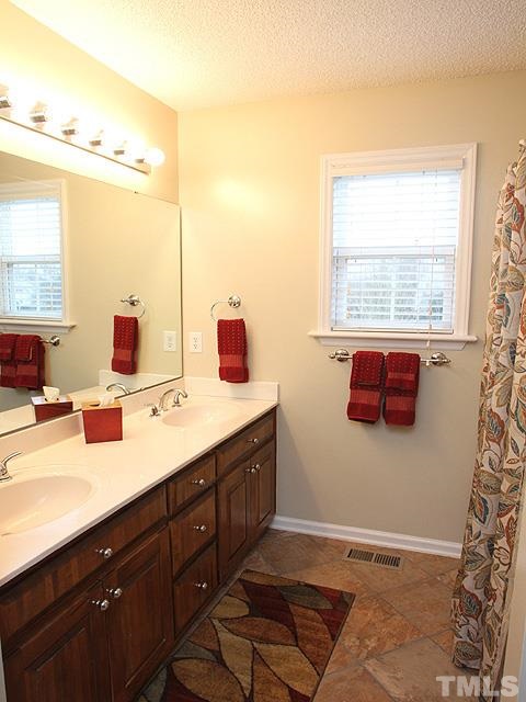 1017 Holland Ridge Drive Raleigh, NC 27603 - Photo 16 of 24 a bathroom with a tub sink and mirror