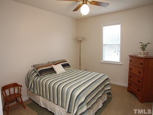 1017 Holland Ridge Drive Raleigh, NC 27603 - Photo 17 of 24 a bedroom with a bed and a chandelier