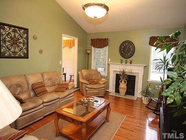 1017 Holland Ridge Drive Raleigh, NC 27603 - Photo 5 of 24 a living room with furniture a fireplace and a potted plant