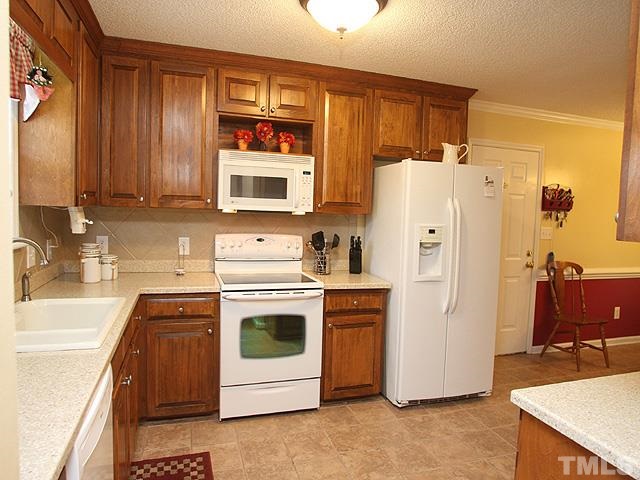 1017 Holland Ridge Drive Raleigh, NC 27603 - Photo 10 of 24 a kitchen with stainless steel appliances and white cabinets