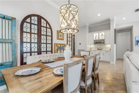 a dining room with furniture a chandelier and wooden floor