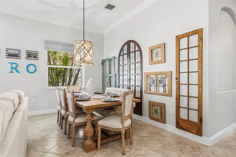a dining room with furniture a chandelier and window