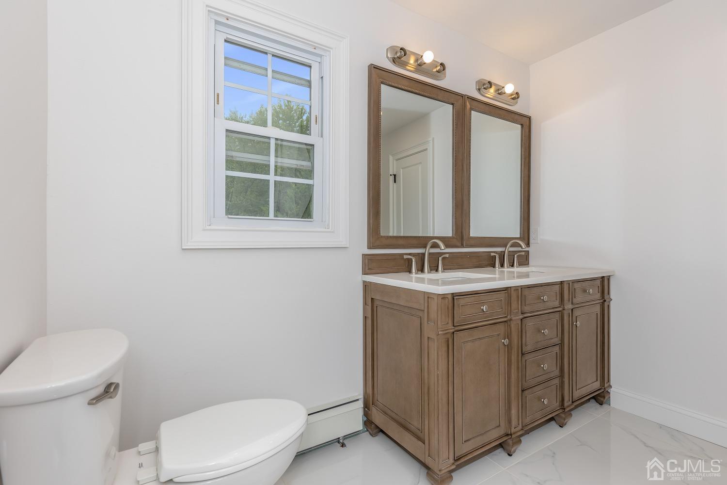 12 Annette Drive Edison, NJ 08820 - Photo 17 of 42 a bathroom with a toilet a sink a mirror and a window