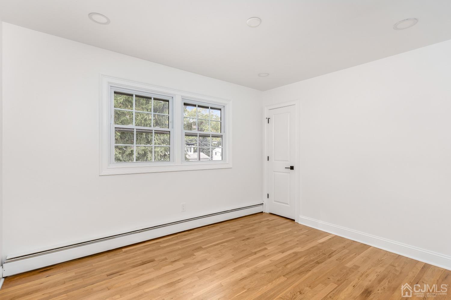 12 Annette Drive Edison, NJ 08820 - Photo 6 of 42 an empty room with wooden floor and windows