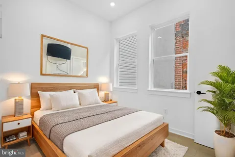 a bedroom with a bed and a potted plant