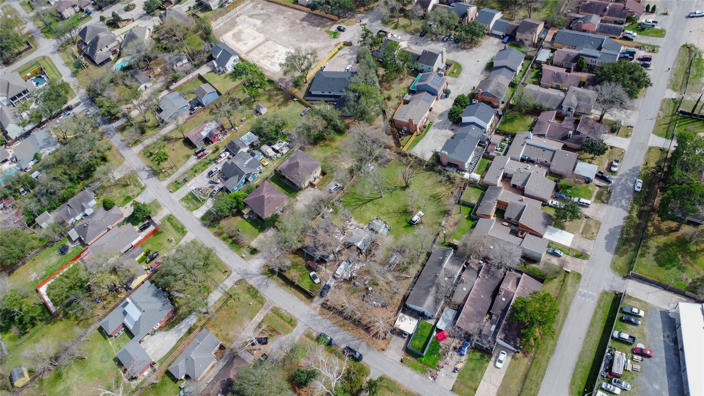 9229 Kerrwood Lane Houston, TX 77080 - Photo 12 of 12 Angled aerial perspective capturing the property within the broader community context, showcasing its substantial footprint and tree canopy in contrast to surrounding homes. The expansive green space and central positioning emphasize subdivision flexibility and future build possibilities. Nearby updated residences and steady neighborhood density reflect ongoing revitalization, supporting strong resale potential for new construction on this prime Spring Branch parcel.