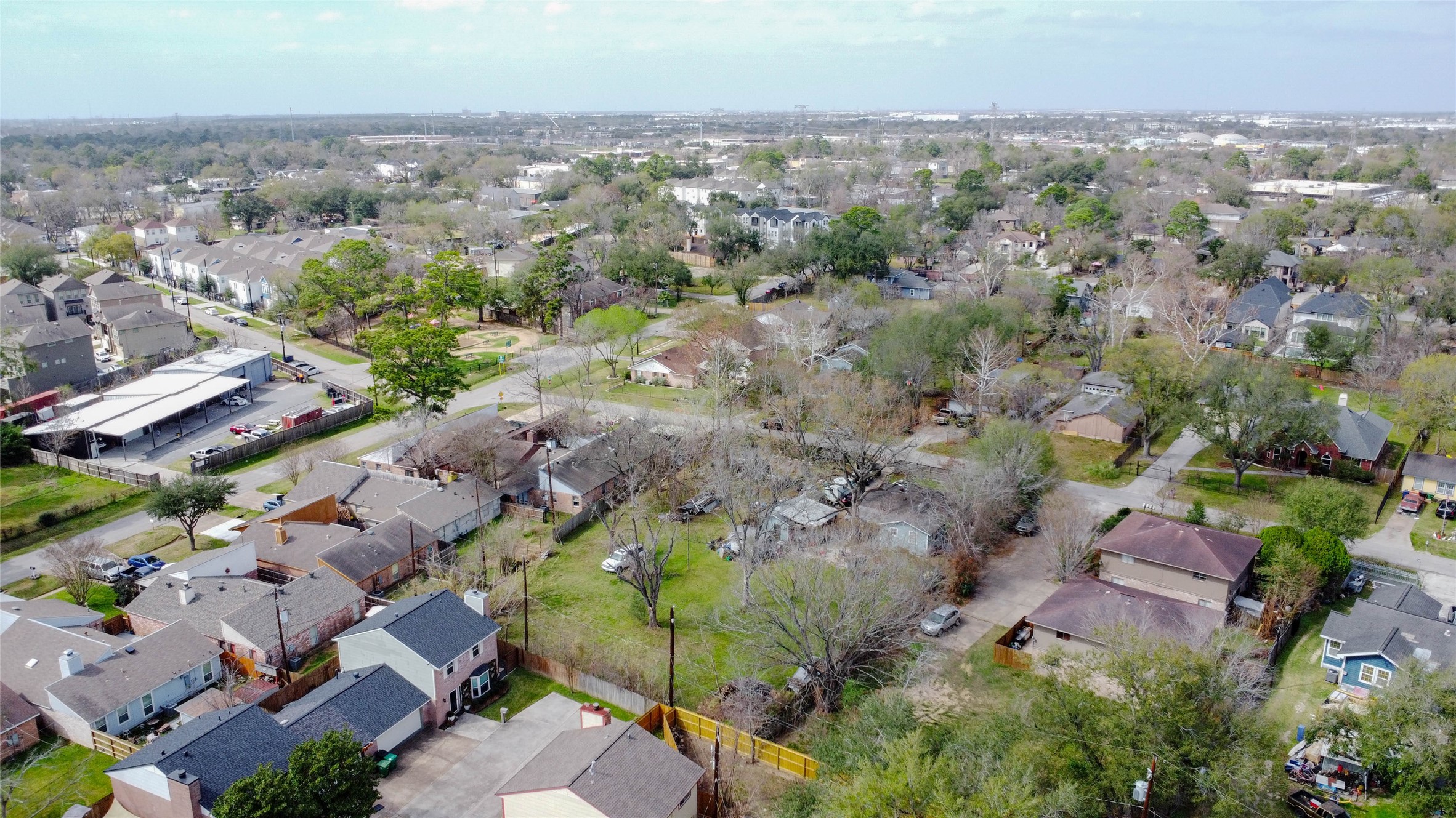 9229 Kerrwood Lane Houston, TX 77080 - Photo 8 of 12 Angled aerial view revealing the open grassy sections of the lot and distribution of mature trees across the property. The substantial depth and width provide multiple layout possibilities for subdivision. Adjacent homes reflect ongoing updates and investment in the area, reinforcing strong resale potential for future development.