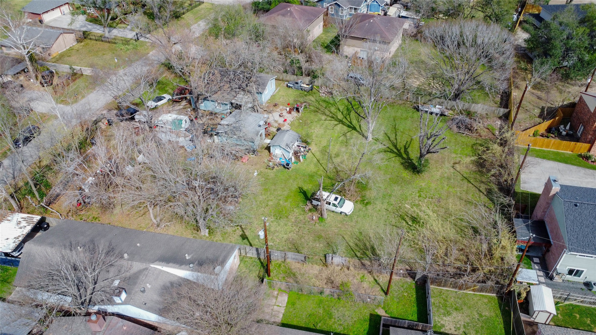 9229 Kerrwood Lane Houston, TX 77080 - Photo 10 of 12 Lower-altitude aerial view providing a clearer look at the interior of the lot, including open buildable space and tree placement. The existing improvements are centrally located, allowing flexibility for reconfiguration. The expansive green area illustrates the property’s subdivision capability and strong potential for thoughtfully planned new homes.
