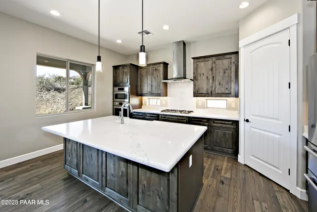 a kitchen with kitchen island white cabinets and stainless steel appliances