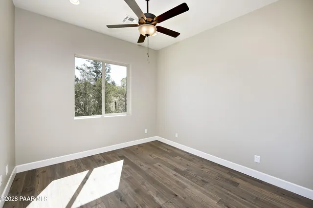 an empty room with a window and a fan