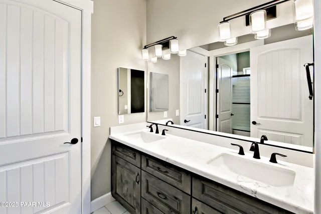 a bathroom with a double vanity sink and a mirror