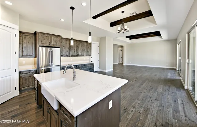 a kitchen with stainless steel appliances granite countertop a refrigerator a sink and a stove