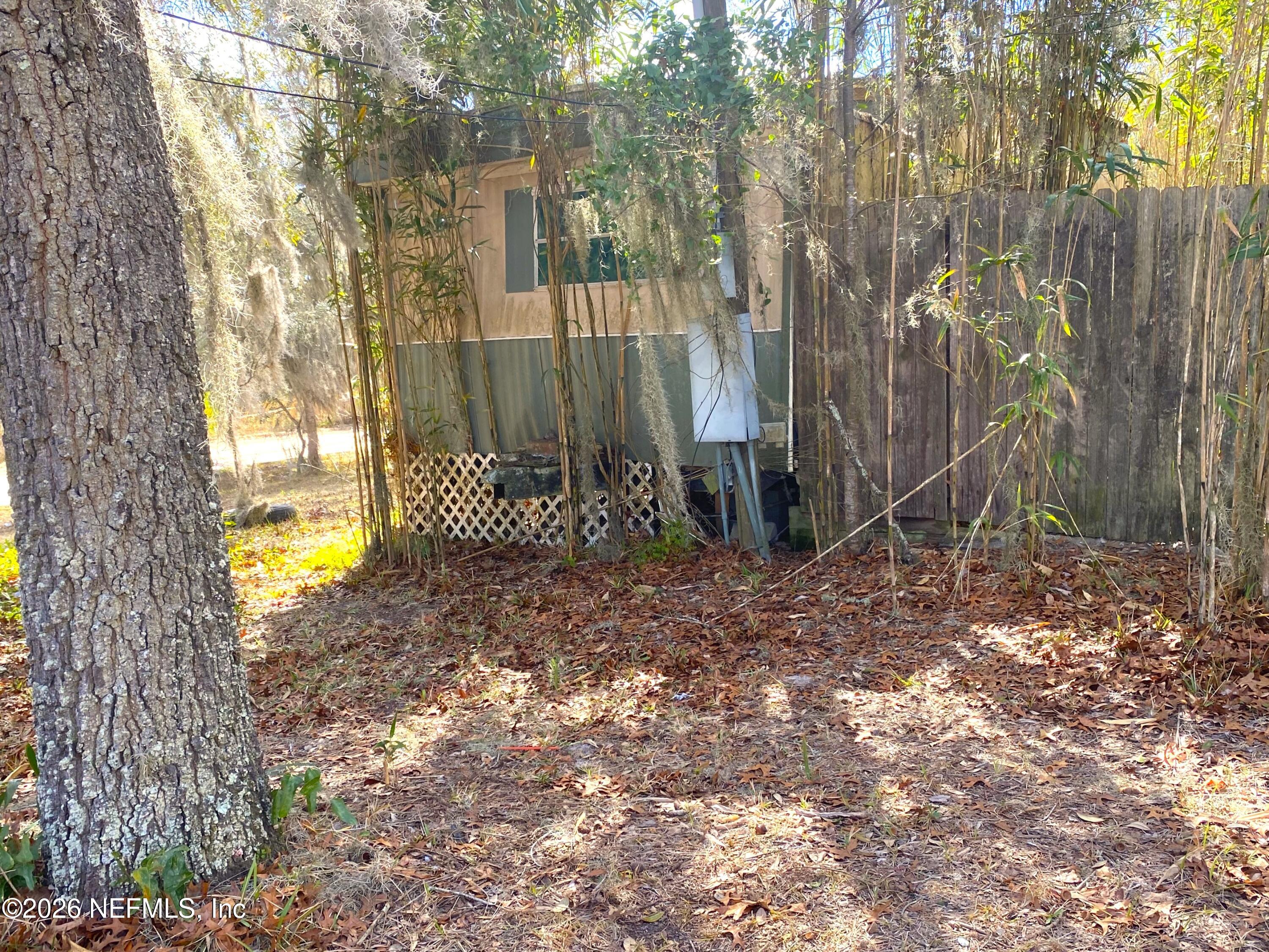 127 Riverside Trail Satsuma, FL 32189 - Photo 10 of 10 a backyard of a house with large trees and wooden fence
