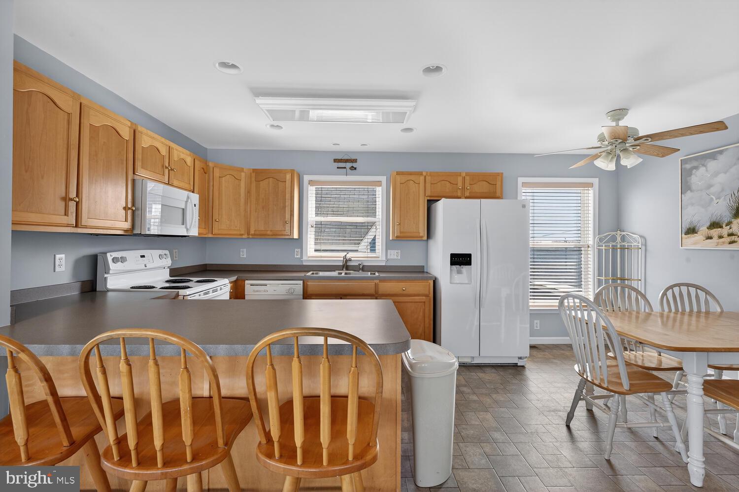 4376 South Bowers Road Milford, DE 19963 - Photo 21 of 46 a kitchen with stainless steel appliances granite countertop a dining table chairs refrigerator and sink