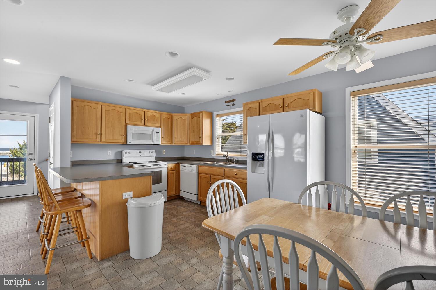4376 South Bowers Road Milford, DE 19963 - Photo 22 of 46 a dining room with stainless steel appliances granite countertop a table chairs and a refrigerator