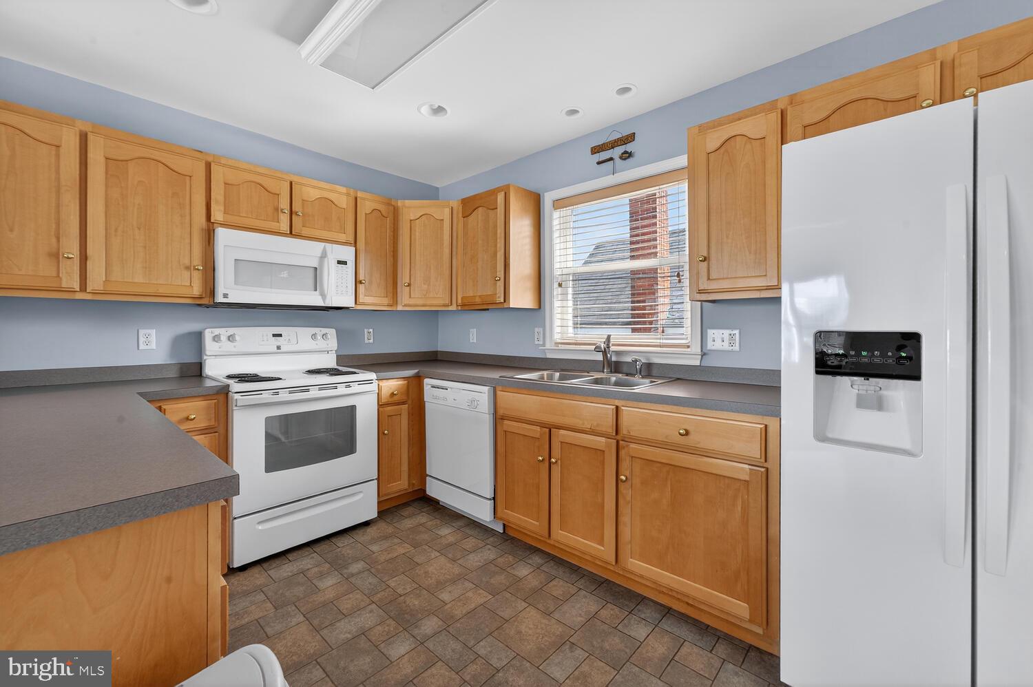 4376 South Bowers Road Milford, DE 19963 - Photo 24 of 46 a kitchen with granite countertop white cabinets sink and white appliances