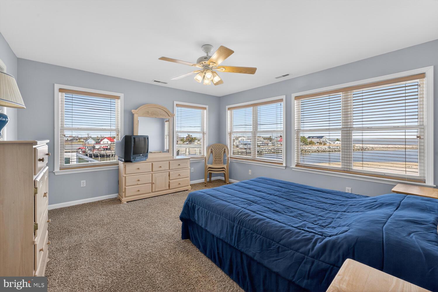 4376 South Bowers Road Milford, DE 19963 - Photo 29 of 46 a spacious bedroom with a bed a dresser a chandelier and a large window
